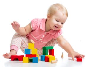 Happy kid playing toy blocks on white background