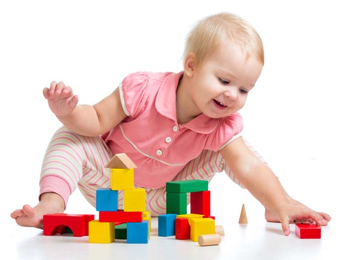 Happy kid playing toy blocks on white background